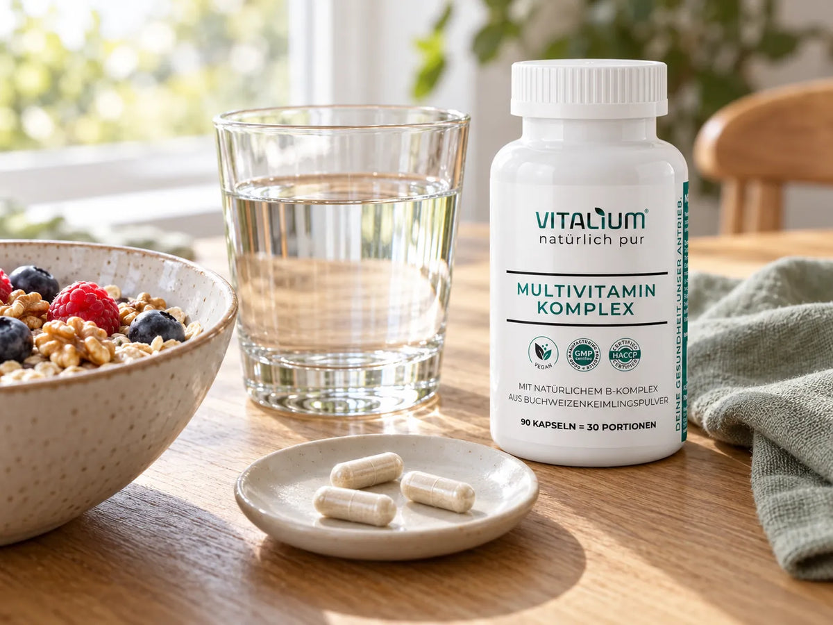 Multivitamin Komplex Dose mit drei Kapseln auf einem Teller neben Müsli und einem Glas Wasser